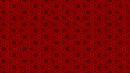A close-up of a red patterned fabric or material swatch with a repeating dark red ornamental motif.