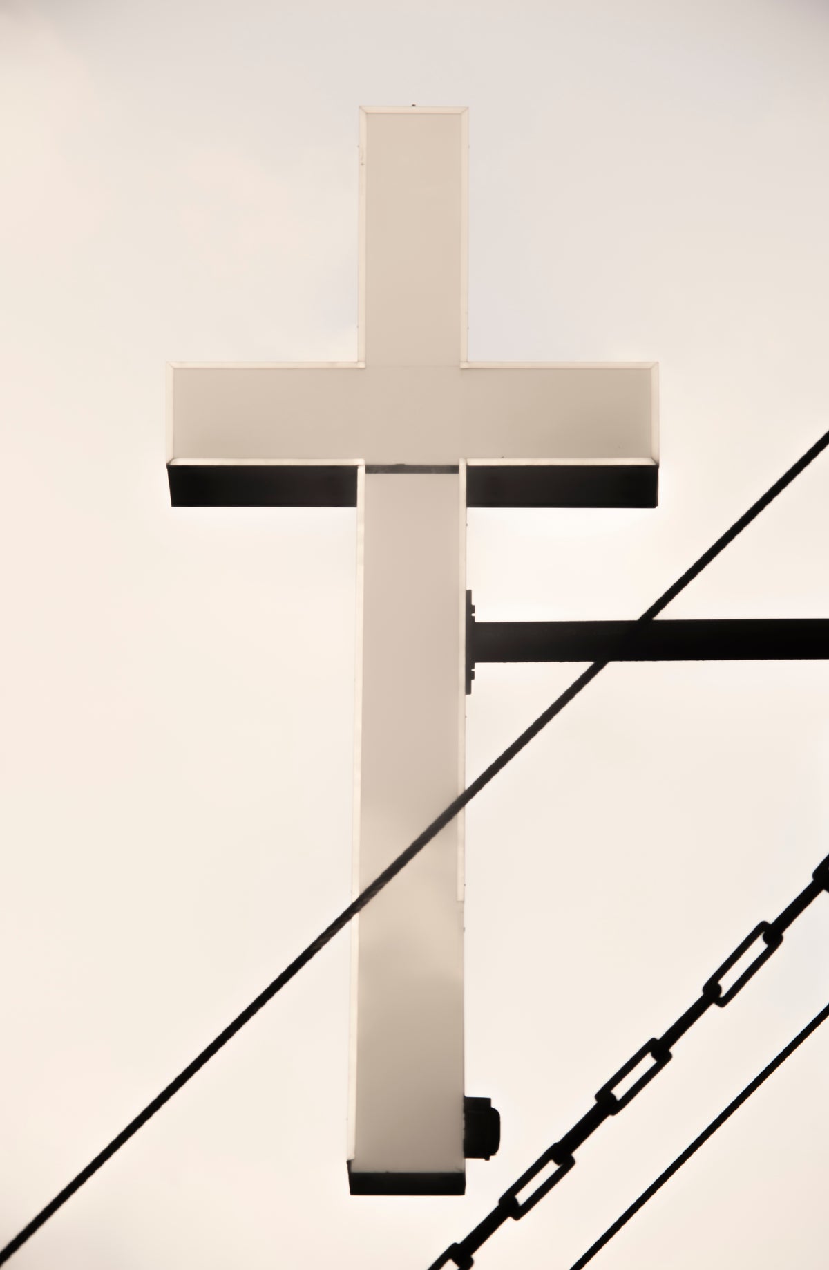 A modern, minimalist white cross cables and a chain in the foreground.