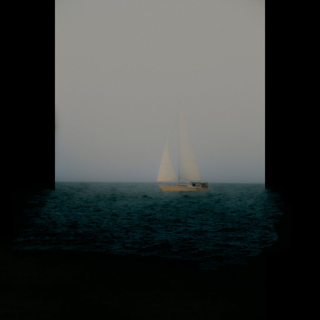 A small sailboat with white sails floats on dark blue water under a pale gray sky, framed by thick black vertical bars on the left and right.