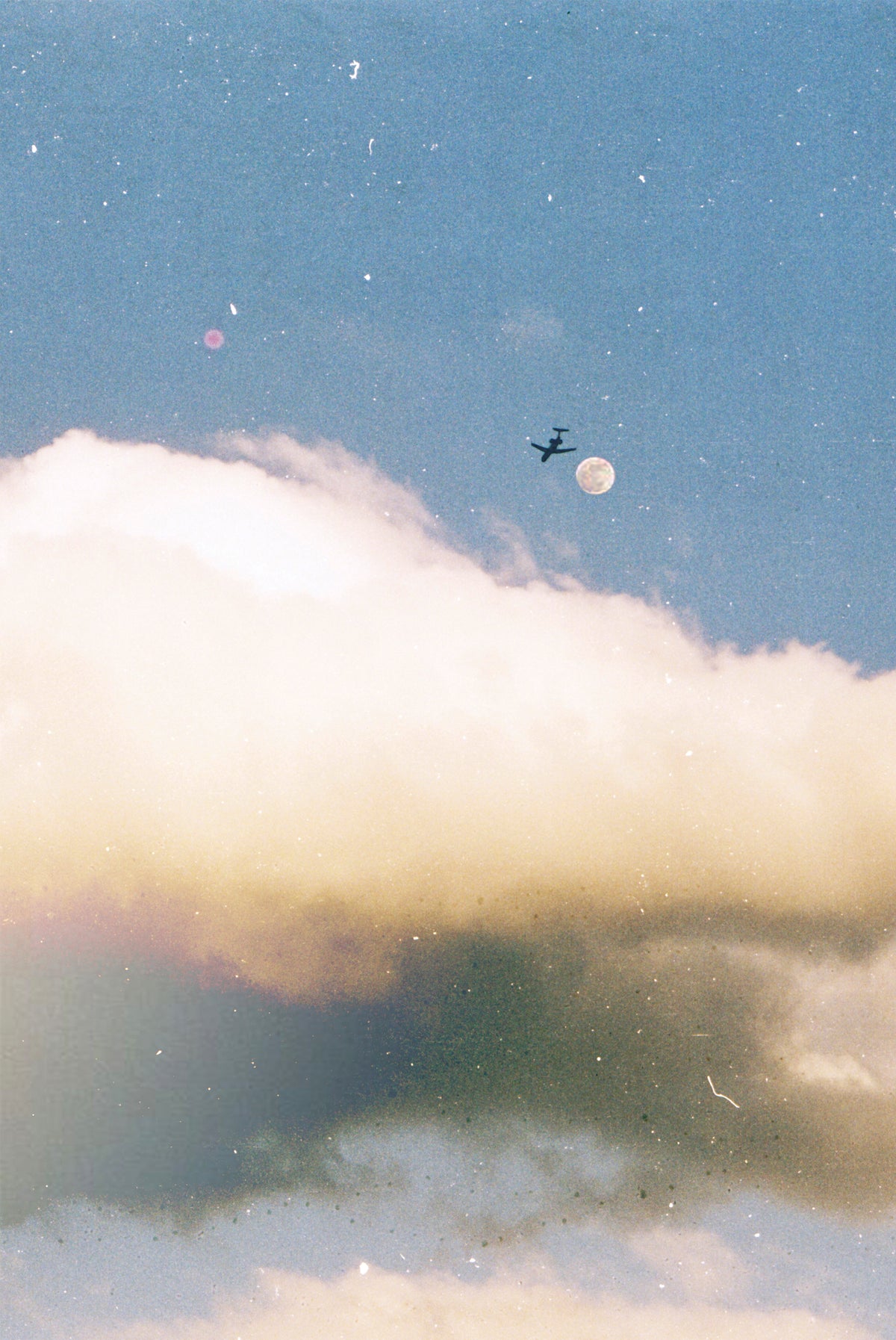 Vintage-style photograph of a small airplane flying near the moon against a blue sky with a large white and gray cloud in the foreground.