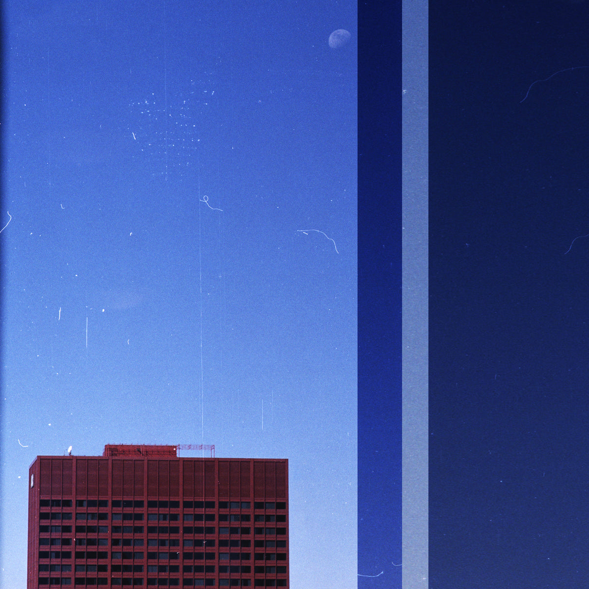 A square art print featuring a minimalist cityscape with a dark red-brown building at the bottom left, a blue sky with a faint moon, and a vertical light blue stripe dividing a dark navy section on the right.